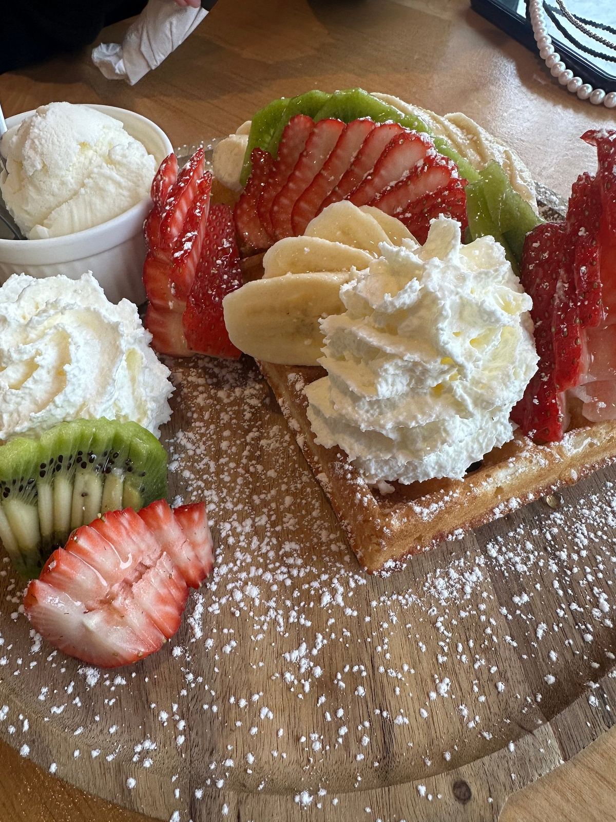 Brussels waffle with strawberries, banana, kiwi, whipped cream and ice cream
