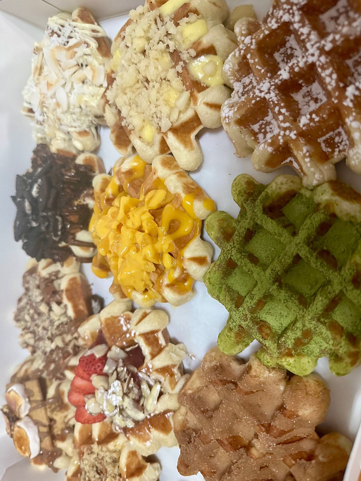 A box of mini Liege waffles in different flavours, from matcha to mango and Oreo